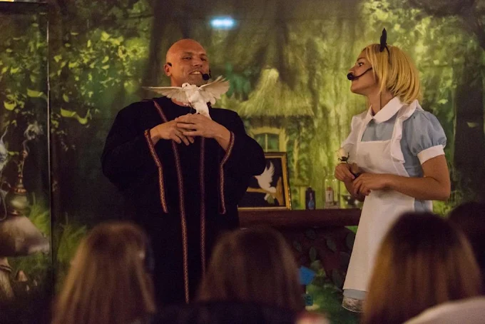 Guglielmo Wilson sul palco con colomba bianca durante uno spettacolo teatrale