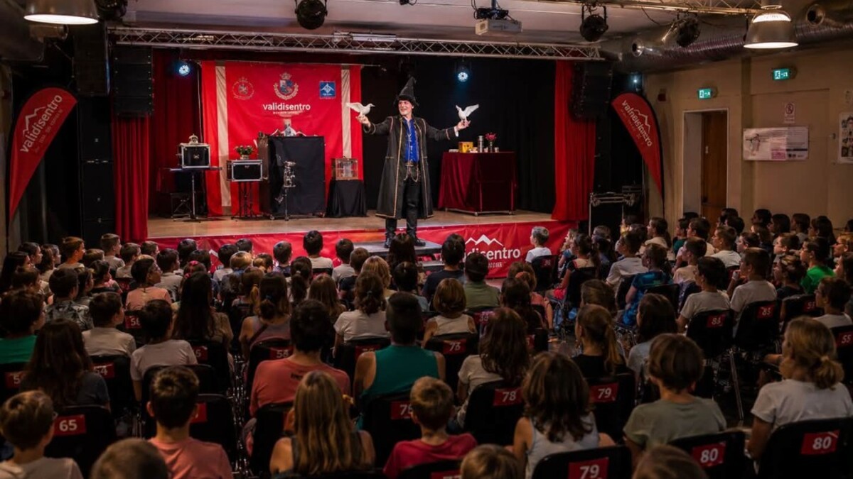 Guglielmo Wilson sul palco con colombe davanti al pubblico di bambini